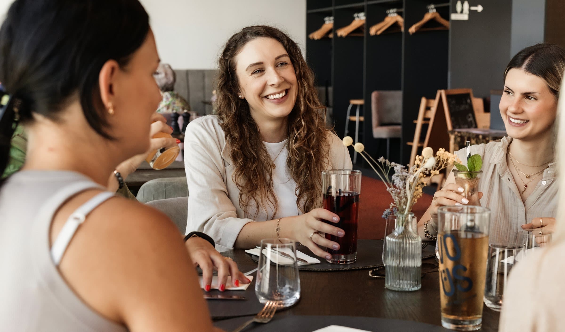 Kolleginnen lachen zusammen beim Mittagessen im Restaurant